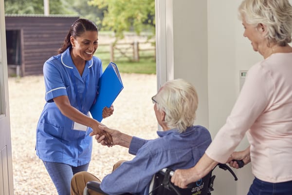 Caregiver greeting a resident at the facility entrance