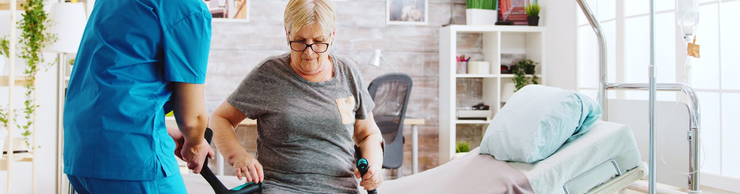 Staff assisting a resident in a facility room