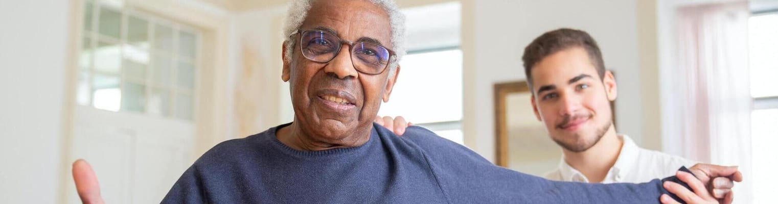 A resident with a staff member in a bright interior setting