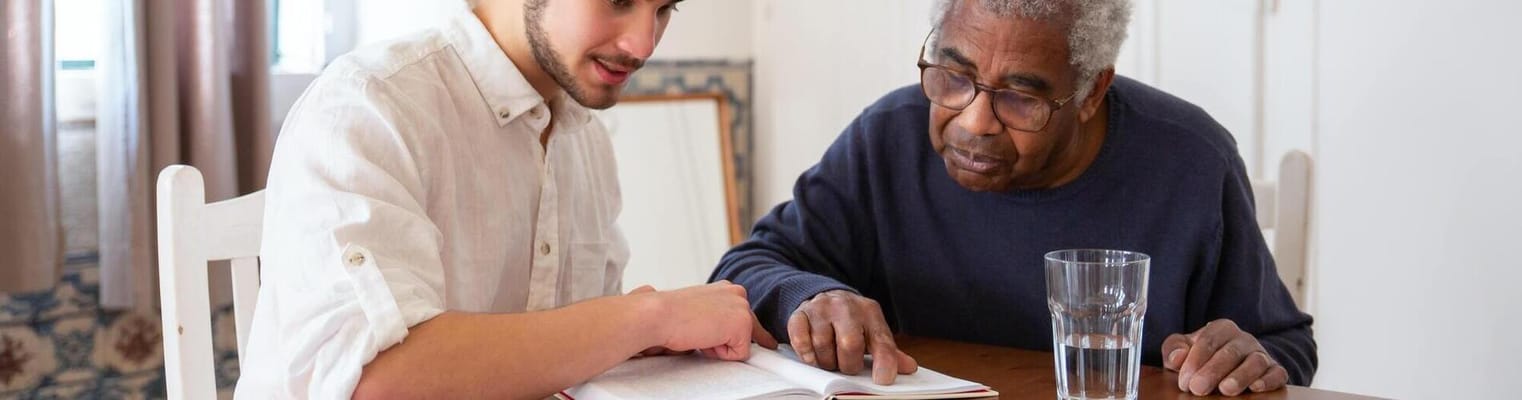 A staff member reading with an elderly resident