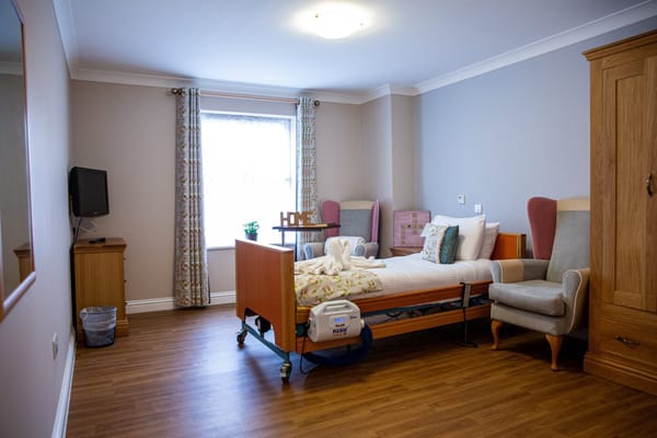 A cozy resident room with a bed and seating area