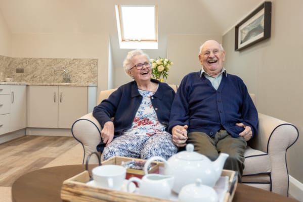Elderly couple happily sitting together in a lounge area