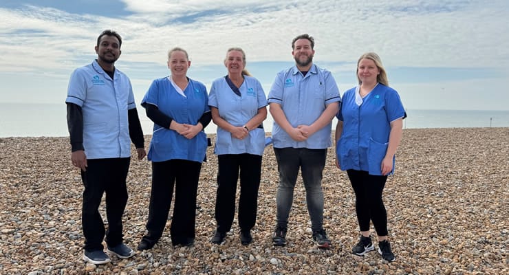 Staff members posing on a beach