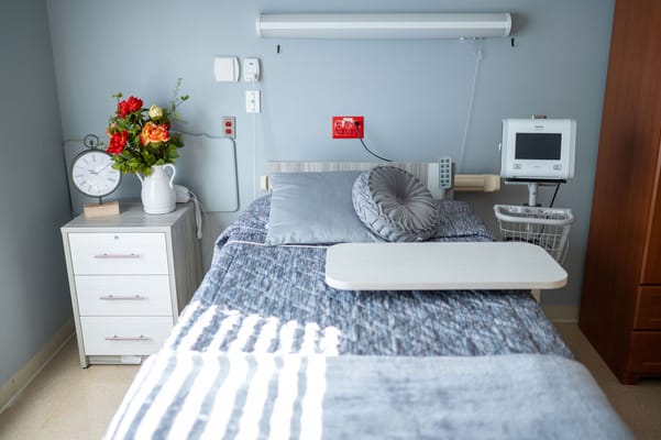 A well-decorated resident room with a bed and floral arrangement