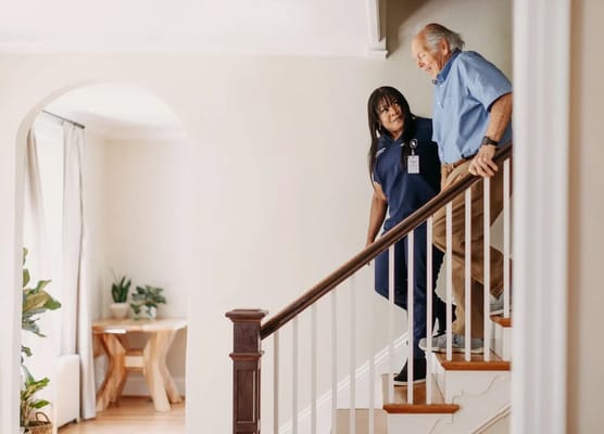 Staff assisting a resident on the staircase