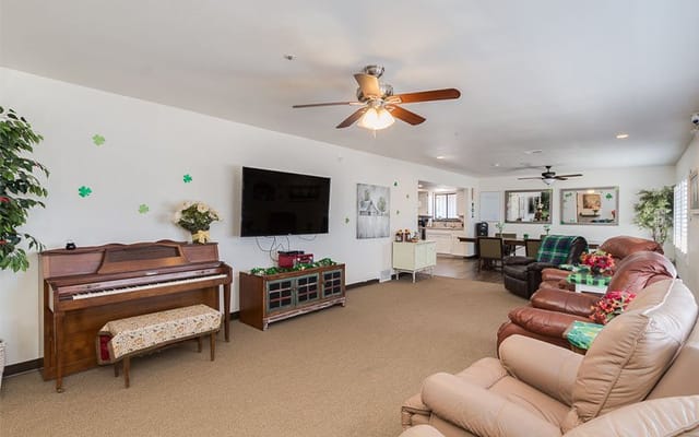 Bright common area with comfortable seating and a piano