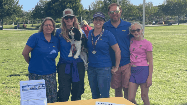 Staff members and a dog at an outdoor event