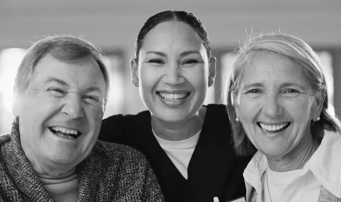 Three smiling individuals in a warm setting