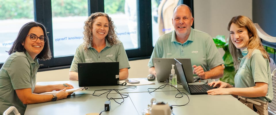 Staff members collaborating around a table with laptops