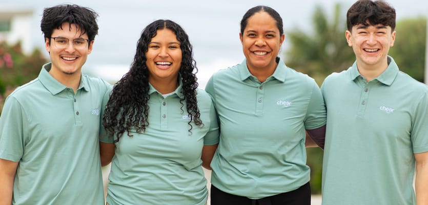 Staff members smiling outdoors in matching shirts