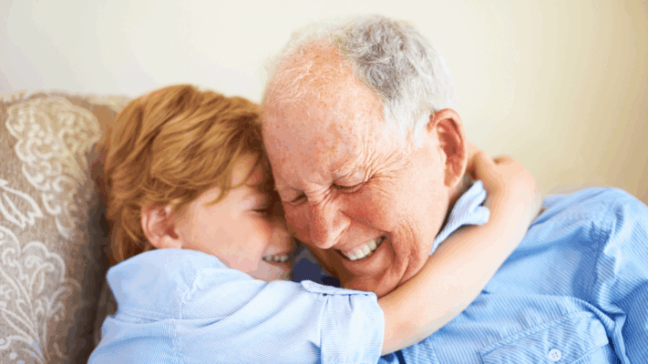 Elderly man laughing with a young child