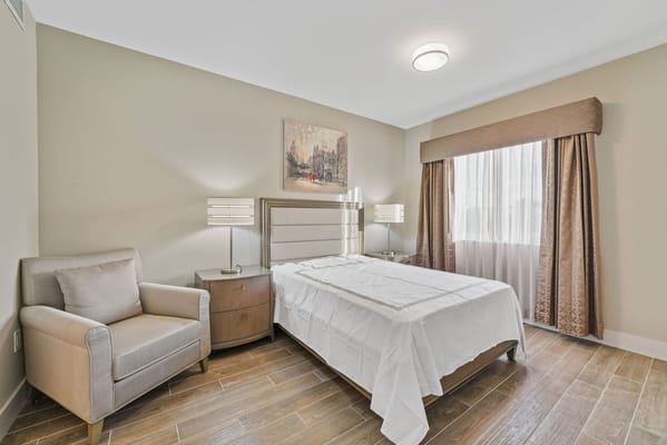 A well-furnished resident room with a bed and seating area