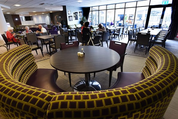 Residents enjoying meals in a dining area.