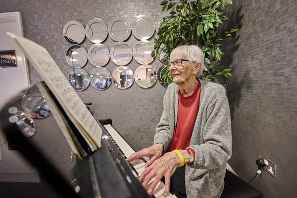 Senior resident playing the piano in a cozy interior