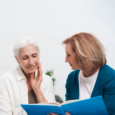 Two women engaged in conversation over a book
