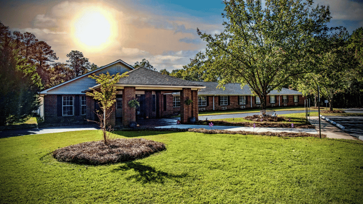Exterior view of Haven Memory Care with gardens and trees