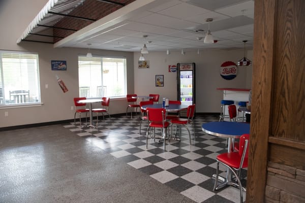 Bright dining area with red chairs and checkered floor