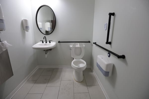 Restroom with sink, toilet, and grab bars