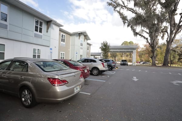 Parking lot with several vehicles near the facility
