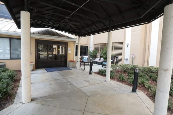 Entrance of a senior living facility with outdoor seating