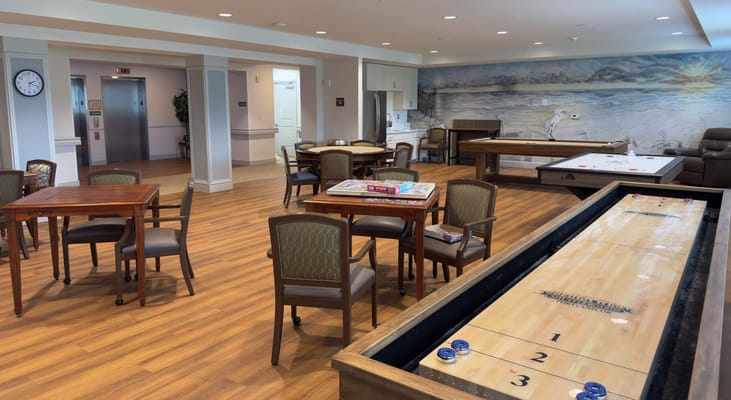 Interior activity area with tables and shuffleboard