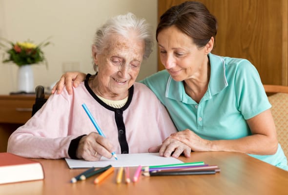 A caregiver assisting a resident with art activities