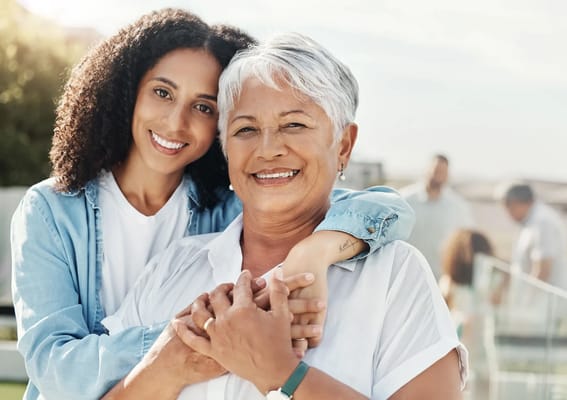 Two women smiling outdoors in a candid moment