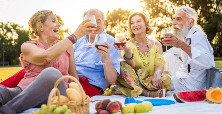 Seniors enjoying a picnic with drinks and fruits