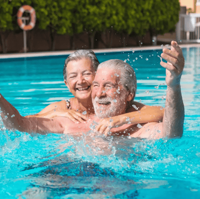 Seniors enjoying a playful moment in a swimming pool