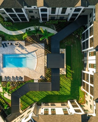 Aerial view of an outdoor pool area surrounded by gardens