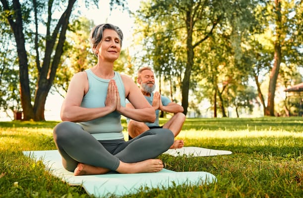 Seniors practicing yoga outdoors in a serene setting