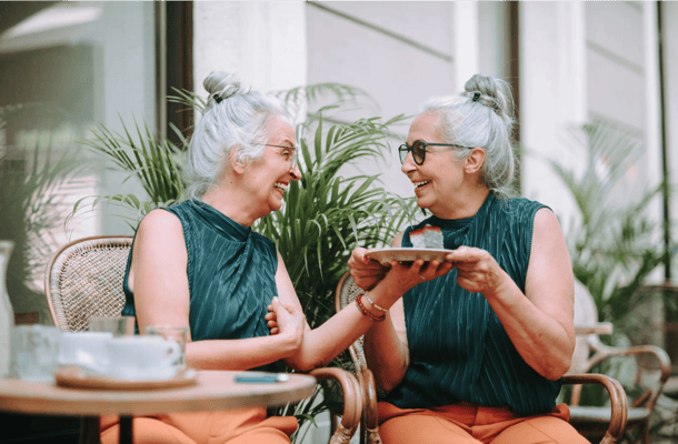 Two senior women sharing a joyful moment outdoors