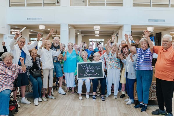 Residents celebrating with a welcome sign in a common area