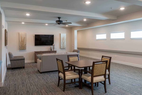 Bright and spacious common area with seating and a TV