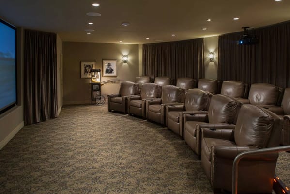 Interior view of a cozy movie theater room with reclining chairs