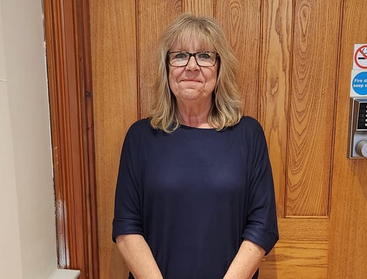 A staff member smiling in a facility hallway