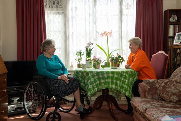 Resident and staff member chatting in a cozy common area