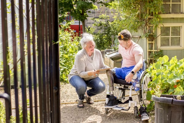 Resident and caregiver interacting in a garden space