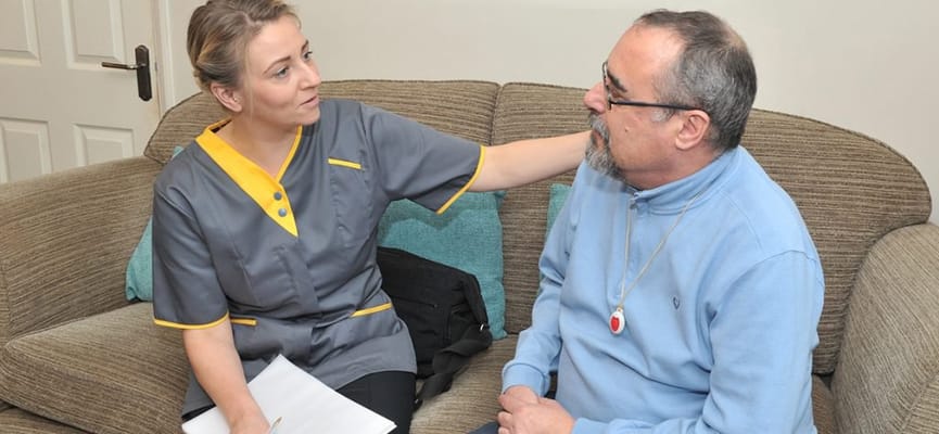 A caregiver discussing with a male resident in a cozy interior