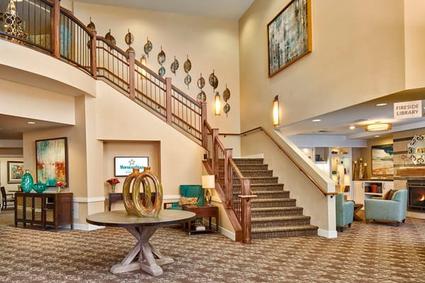 Bright interior lobby with decorative staircase and seating