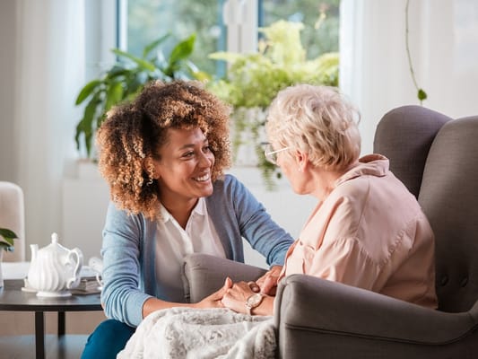 Caregiver interacting with a senior resident in a cozy setting