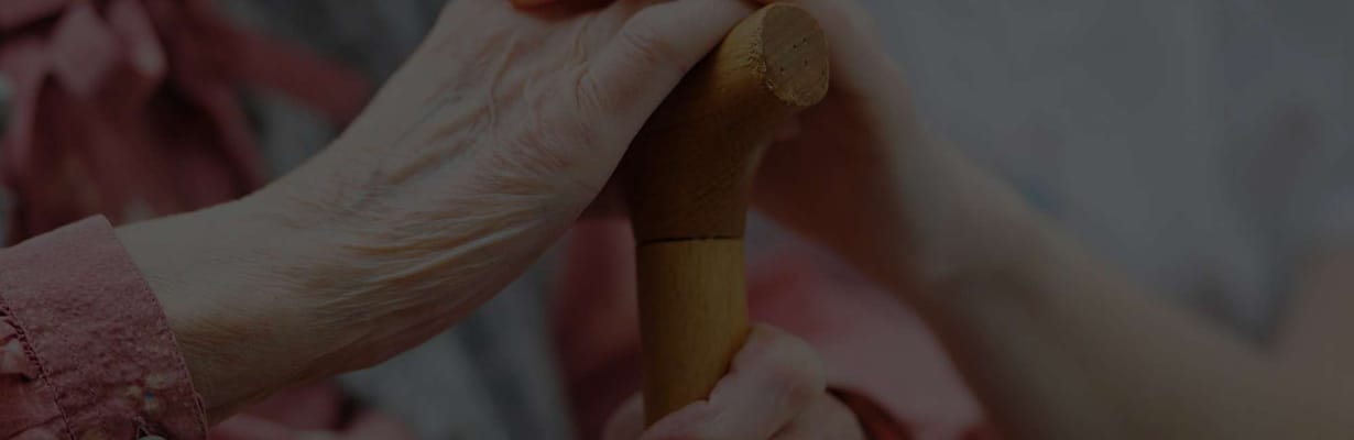 Close-up of two hands holding a walking cane