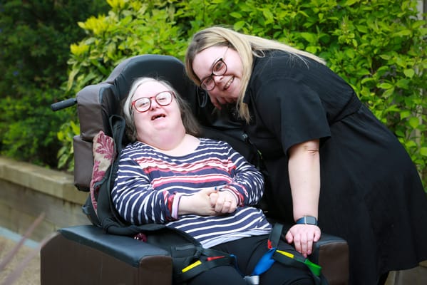 A resident enjoying time with a staff member outdoors