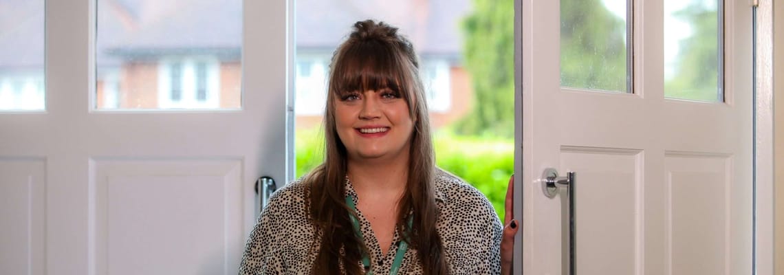 Staff member smiling at the entrance of the facility