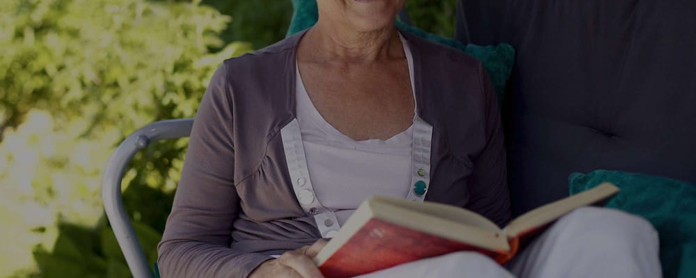 Senior resident enjoying a book outdoors