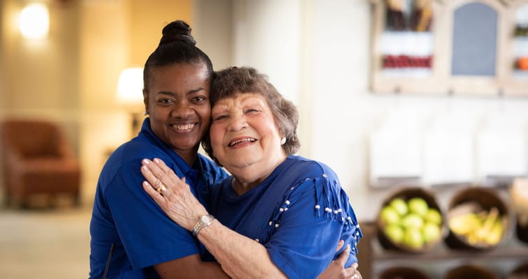 Staff member with a resident smiling together in a common area