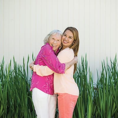 A resident and staff member happily embracing outdoors