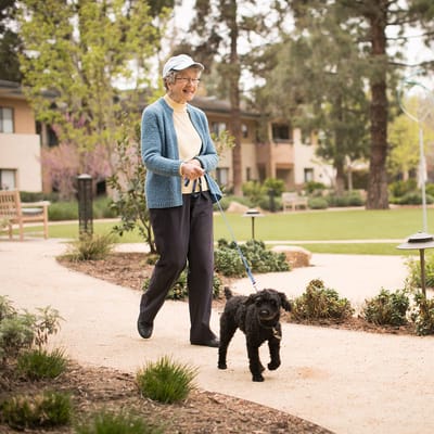 A resident walking a dog in a garden area