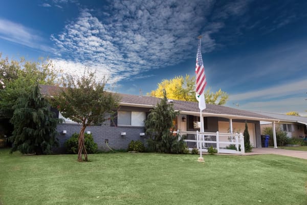 Exterior view of an assisted living facility with a flag