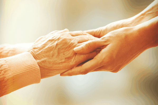A close-up of hands holding each other warmly